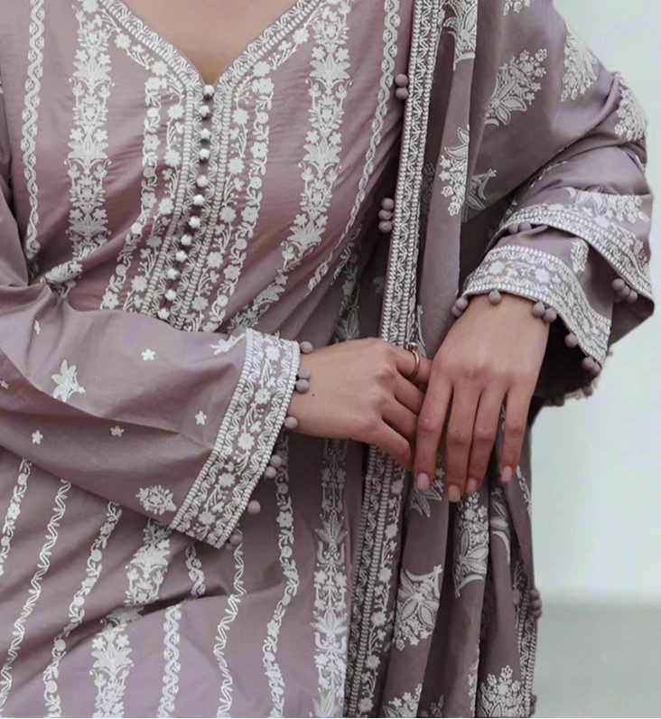 Purple embroidered dress with white patterns on a neutral background